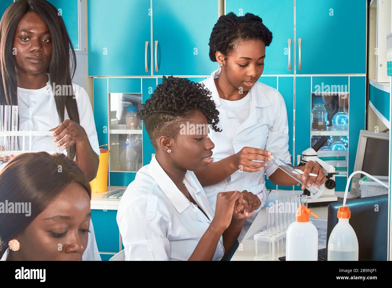 Étudiantes africaines étudiants en médecine, jeunes diplômés en recherche, laboratoire de tests médicaux effectuant divers tests sur des échantillons. Biopsie d'analyse microscopique, pcr Banque D'Images