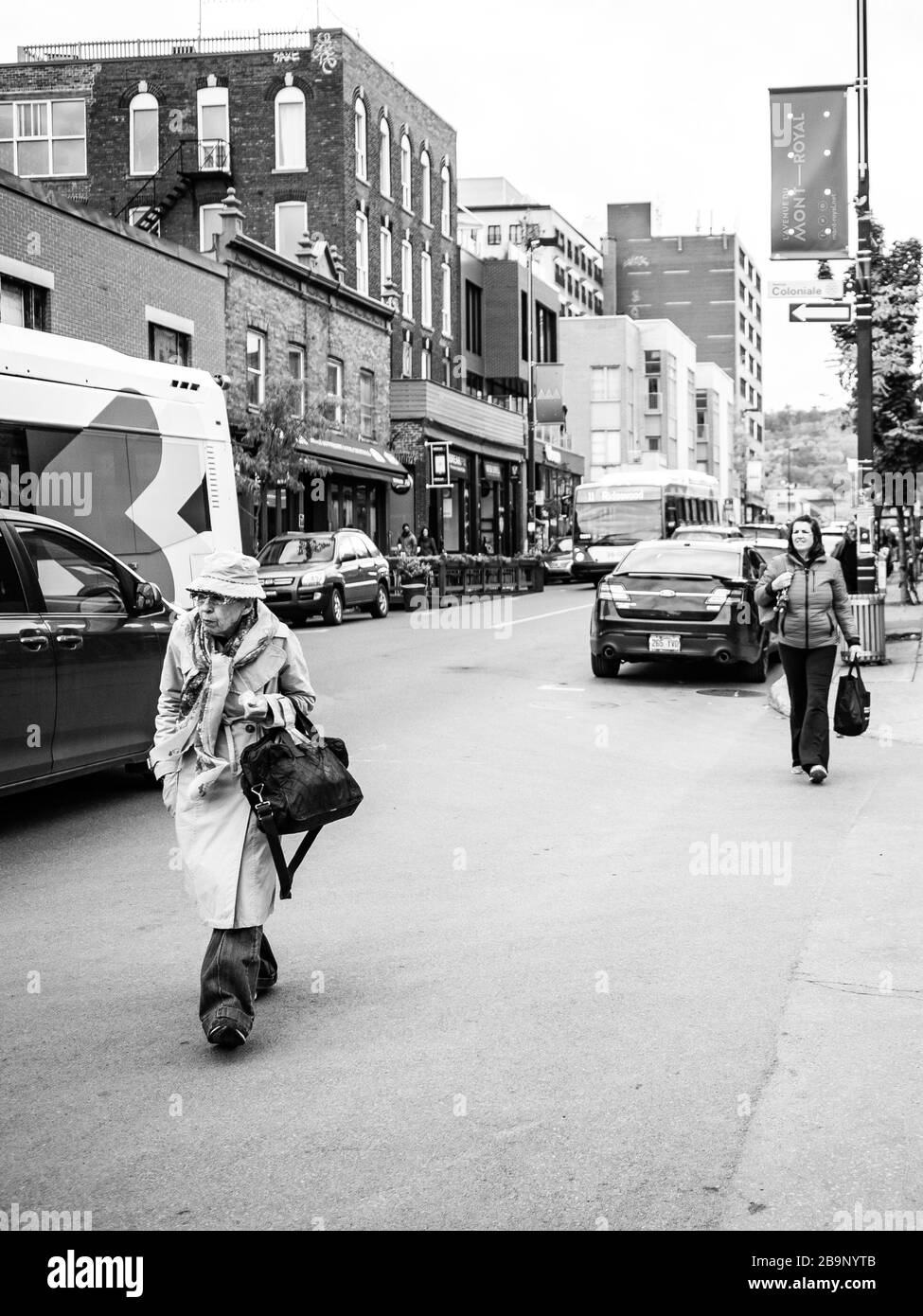 Photographie de rue d'une vieille dame marchant dans la ville B&W Banque D'Images
