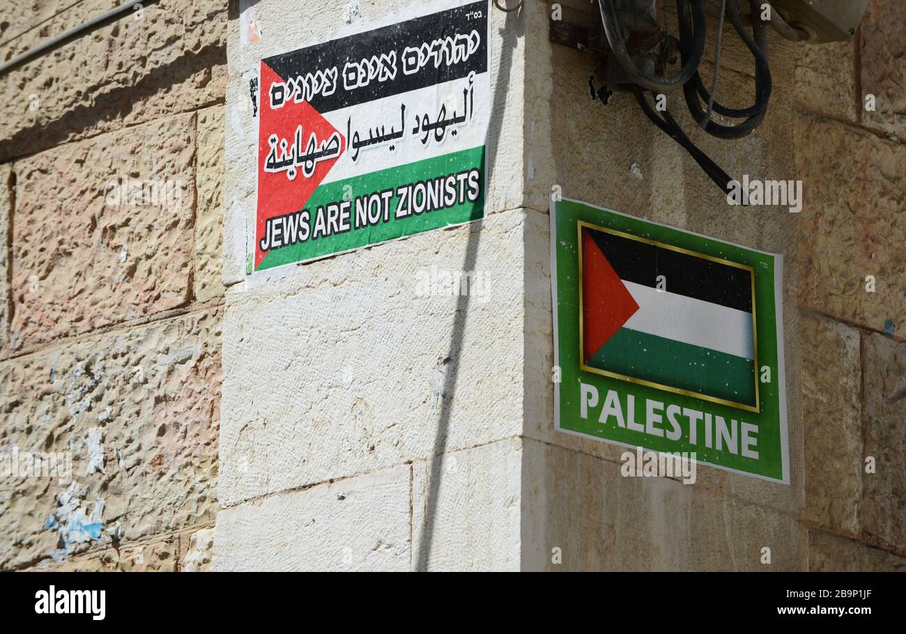 Les Juifs ne sont pas des slogans sionistes avec des drapeaux palestiniens ornent les murs des bâtiments du quartier ultra-orthodoxe de Mea Shearim à Jérusalem. Banque D'Images