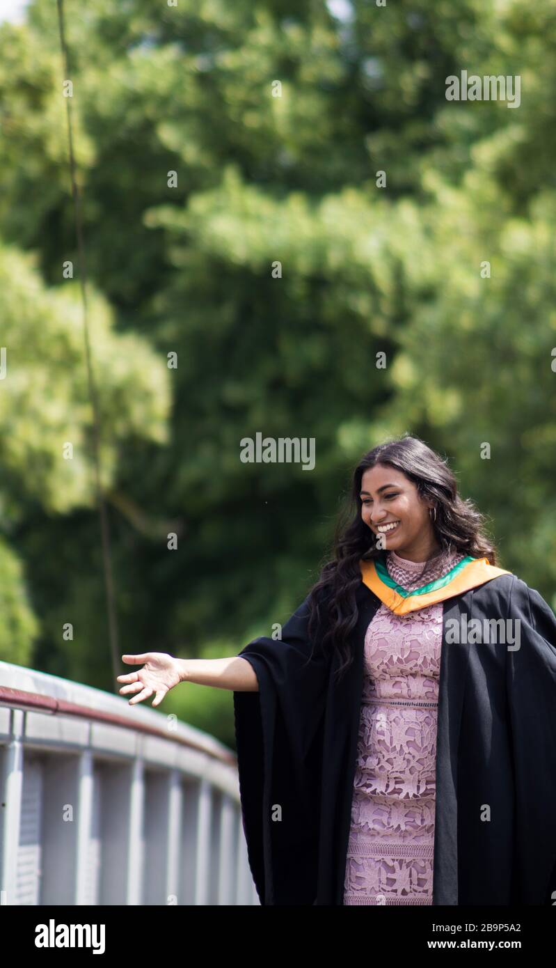 Photographies de graduation d'une femme indienne en plein air, avec des fleurs. Banque D'Images