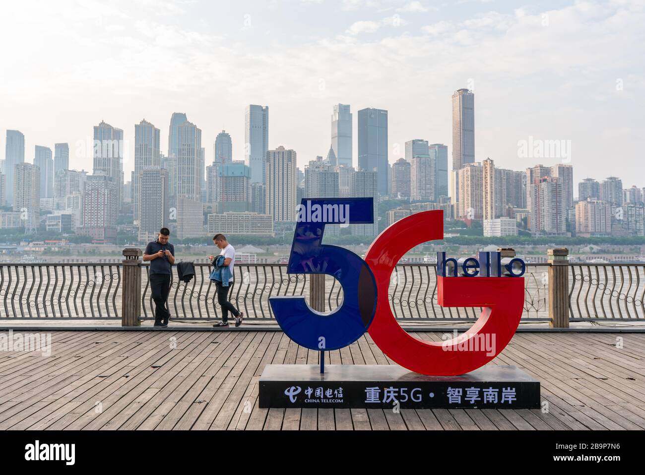 Les personnes utilisant un smartphone près d'un panneau de 5 G. Banque D'Images