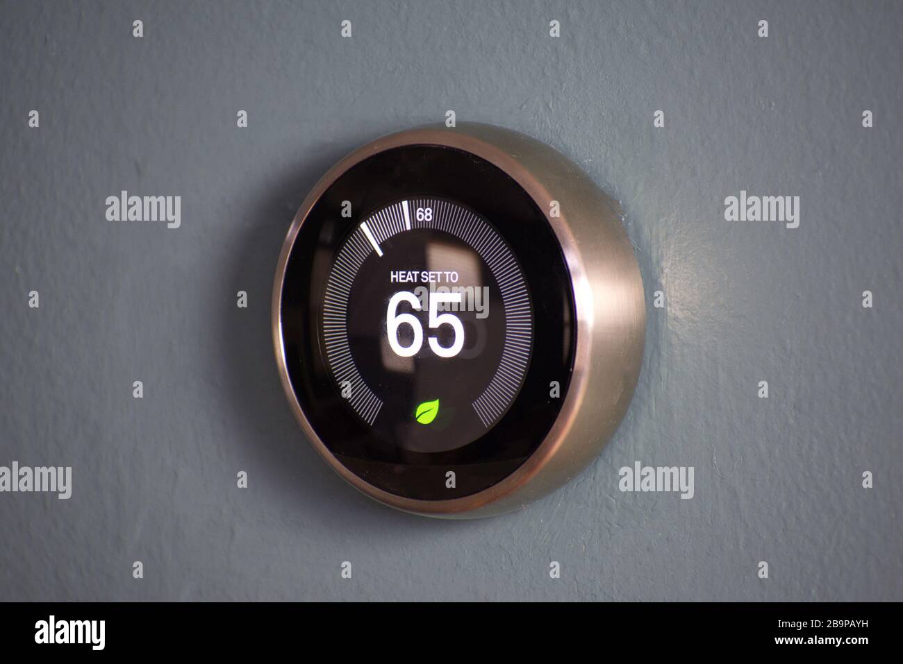 Thermostat domestique intelligent affichant la température à une économie d'énergie de 65 degrés. Température du nid Banque D'Images