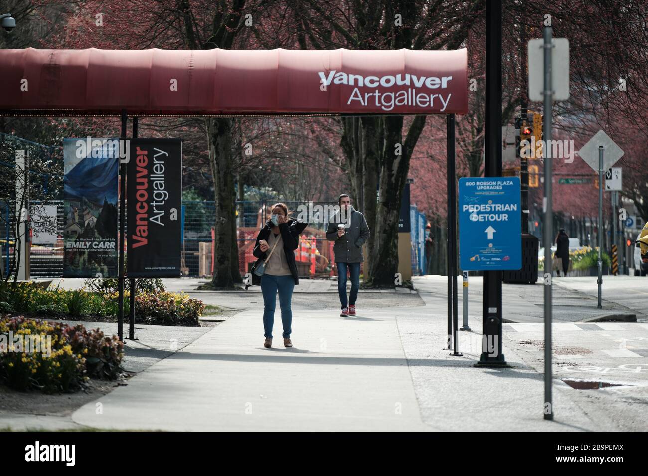 VANCOUVER, C.-B., CANADA - 24 MARS 2020 : les civils portent des vêtements de protection tels que le masque et les gants en raison de l'achat de panique comme le coronavirus se répand. Banque D'Images