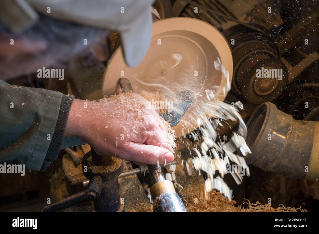Fabrication d'un bol en bois sur un tour dans un vieux petit atelier avec  des copeaux de bois volants Photo Stock - Alamy