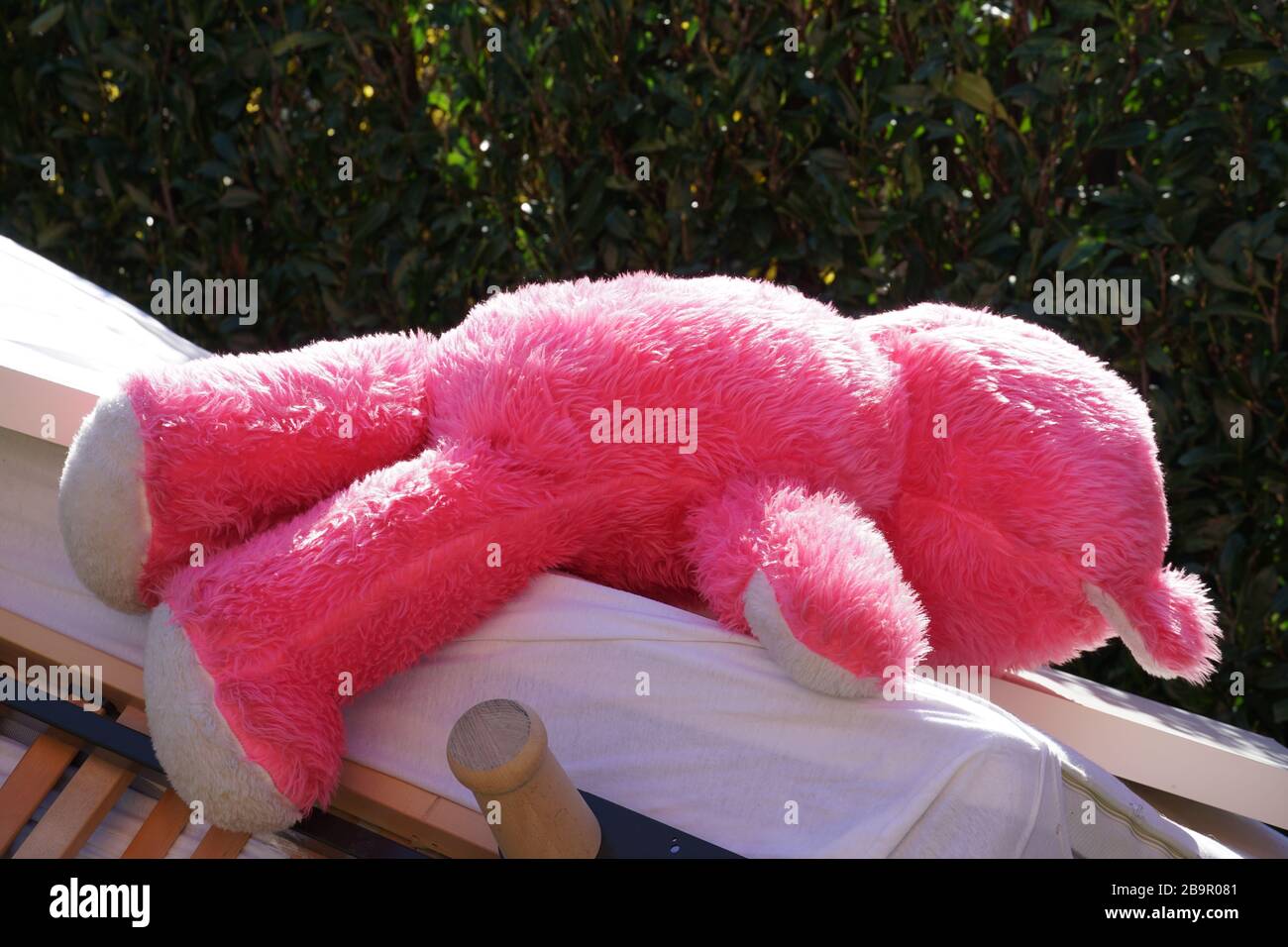 Vieux meubles disjoints sur une pile avec un grand ours en peluche rose couché sur elle. Le tas est principalement constitué de la construction de lit. Banque D'Images