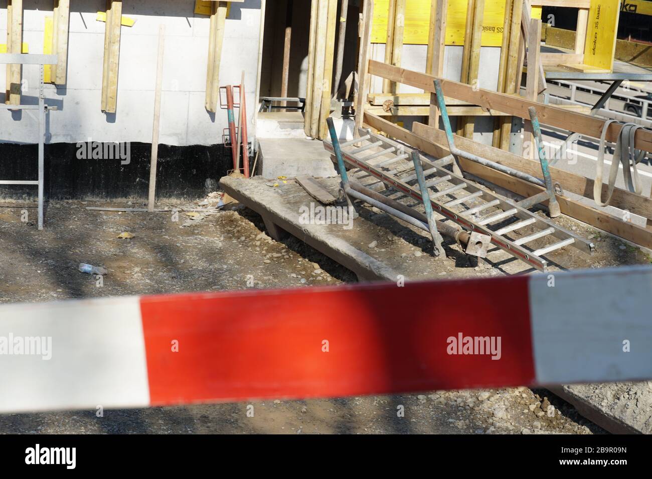 Une seule barrière planche en rouge et blanc sur un bâtiment ou un chantier de génie civil. Banque D'Images