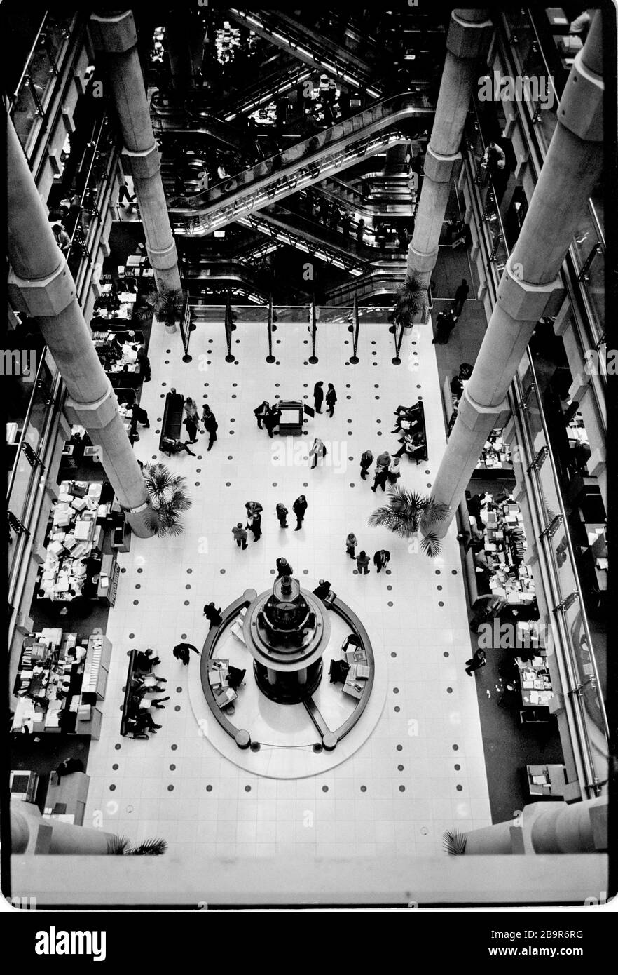 Ville de Londres. Lloyd’s de London Insurance Trading Floor photographié avec la permission de 1988. Lloyd's de Londres, généralement connu tout simplement sous le nom de Lloyd's, est un marché d'assurance et de réassurance situé à Londres, au Royaume-Uni. Contrairement à la plupart de ses concurrents dans l'industrie, il ne s'agit pas d'une compagnie d'assurance; Lloyd's est plutôt un organisme d'entreprise régi par la Lloyd's Act 1871 et les lois du Parlement qui en découlent. Il fonctionne comme un marché partiellement mutualisé au sein duquel plusieurs bailleurs de fonds financiers, regroupés en syndicats, se rassemblent pour regrouper et répartir le risque. Ces souscripteurs, ou « membres », sont un Banque D'Images