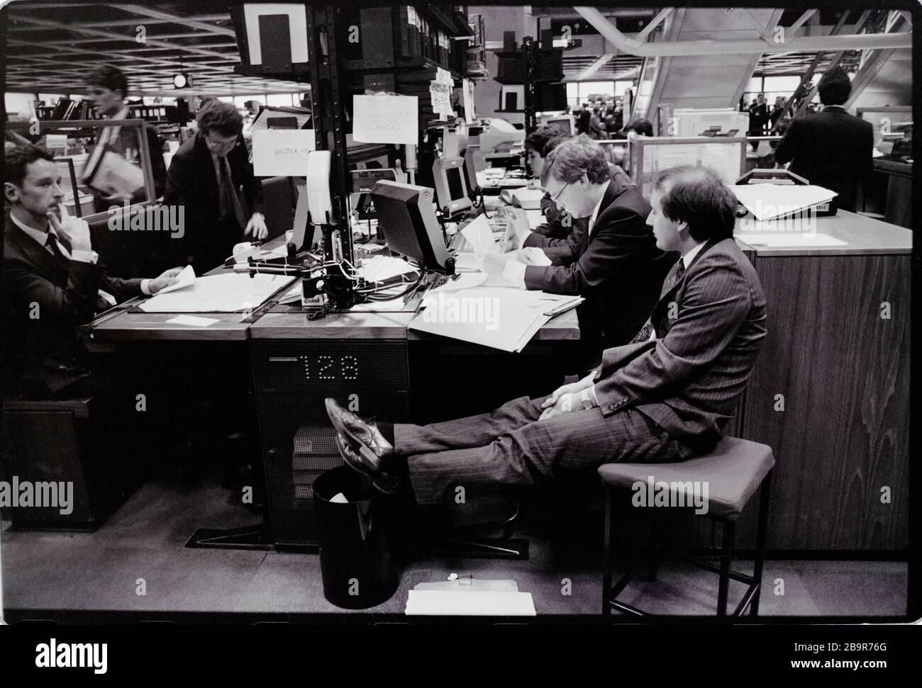 Ville de Londres. Lloyd’s de London Insurance Trading Floor photographié avec la permission de 1988. Lloyd's de Londres, généralement connu tout simplement sous le nom de Lloyd's, est un marché d'assurance et de réassurance situé à Londres, au Royaume-Uni. Contrairement à la plupart de ses concurrents dans l'industrie, il ne s'agit pas d'une compagnie d'assurance; Lloyd's est plutôt un organisme d'entreprise régi par la Lloyd's Act 1871 et les lois du Parlement qui en découlent. Il fonctionne comme un marché partiellement mutualisé au sein duquel plusieurs bailleurs de fonds financiers, regroupés en syndicats, se rassemblent pour regrouper et répartir le risque. Ces souscripteurs, ou « membres », sont un Banque D'Images