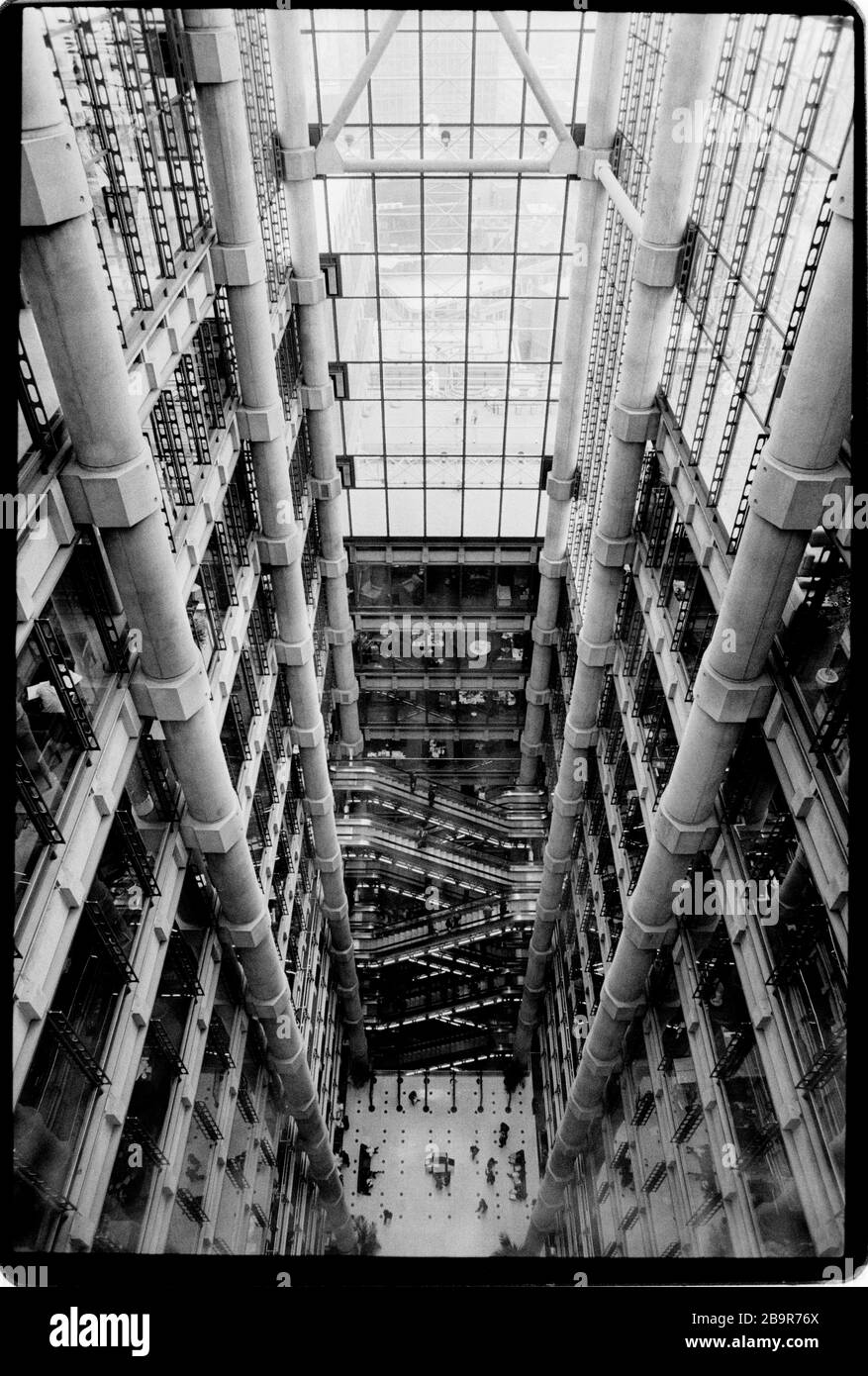 Ville de Londres. Lloyd’s de London Insurance Trading Floor photographié avec la permission de 1988. Lloyd's de Londres, généralement connu tout simplement sous le nom de Lloyd's, est un marché d'assurance et de réassurance situé à Londres, au Royaume-Uni. Contrairement à la plupart de ses concurrents dans l'industrie, il ne s'agit pas d'une compagnie d'assurance; Lloyd's est plutôt un organisme d'entreprise régi par la Lloyd's Act 1871 et les lois du Parlement qui en découlent. Il fonctionne comme un marché partiellement mutualisé au sein duquel plusieurs bailleurs de fonds financiers, regroupés en syndicats, se rassemblent pour regrouper et répartir le risque. Ces souscripteurs, ou « membres », sont un Banque D'Images