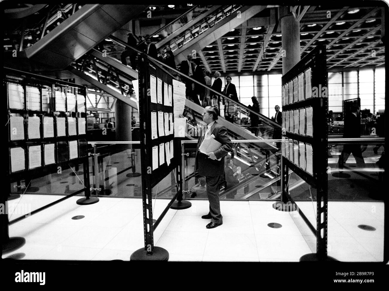Ville de Londres. Lloyd’s de London Insurance Trading Floor photographié avec la permission de 1988. Lloyd's de Londres, généralement connu tout simplement sous le nom de Lloyd's, est un marché d'assurance et de réassurance situé à Londres, au Royaume-Uni. Contrairement à la plupart de ses concurrents dans l'industrie, il ne s'agit pas d'une compagnie d'assurance; Lloyd's est plutôt un organisme d'entreprise régi par la Lloyd's Act 1871 et les lois du Parlement qui en découlent. Il fonctionne comme un marché partiellement mutualisé au sein duquel plusieurs bailleurs de fonds financiers, regroupés en syndicats, se rassemblent pour regrouper et répartir le risque. Ces souscripteurs, ou « membres », sont un Banque D'Images
