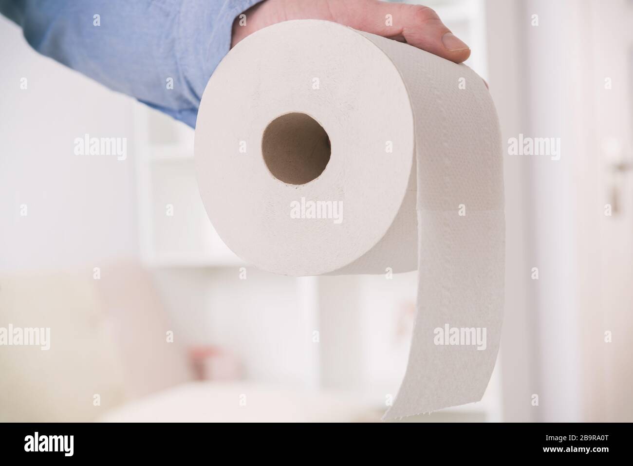 Main tenant papier toilette à la maison Banque D'Images