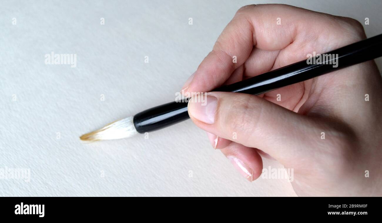 Brosse à la main pour dessiner sur blanc Banque D'Images