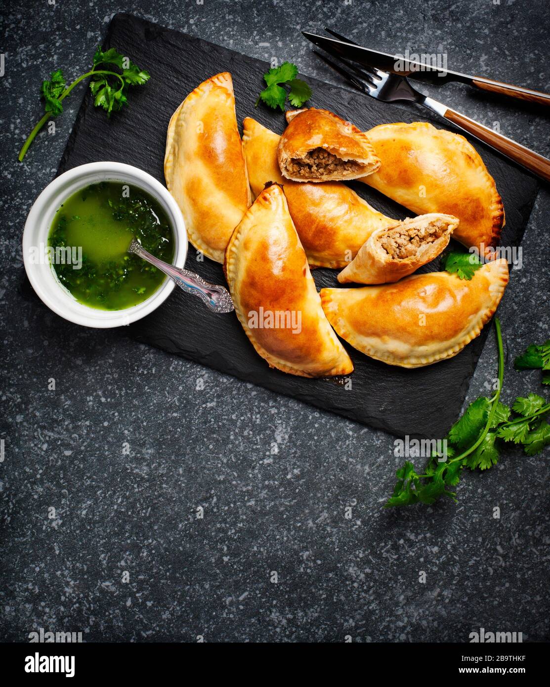 Empanadas avec sauce chimichuri. Cuisine de tradition latino-américaine. Vue de dessus, espace de copie Banque D'Images