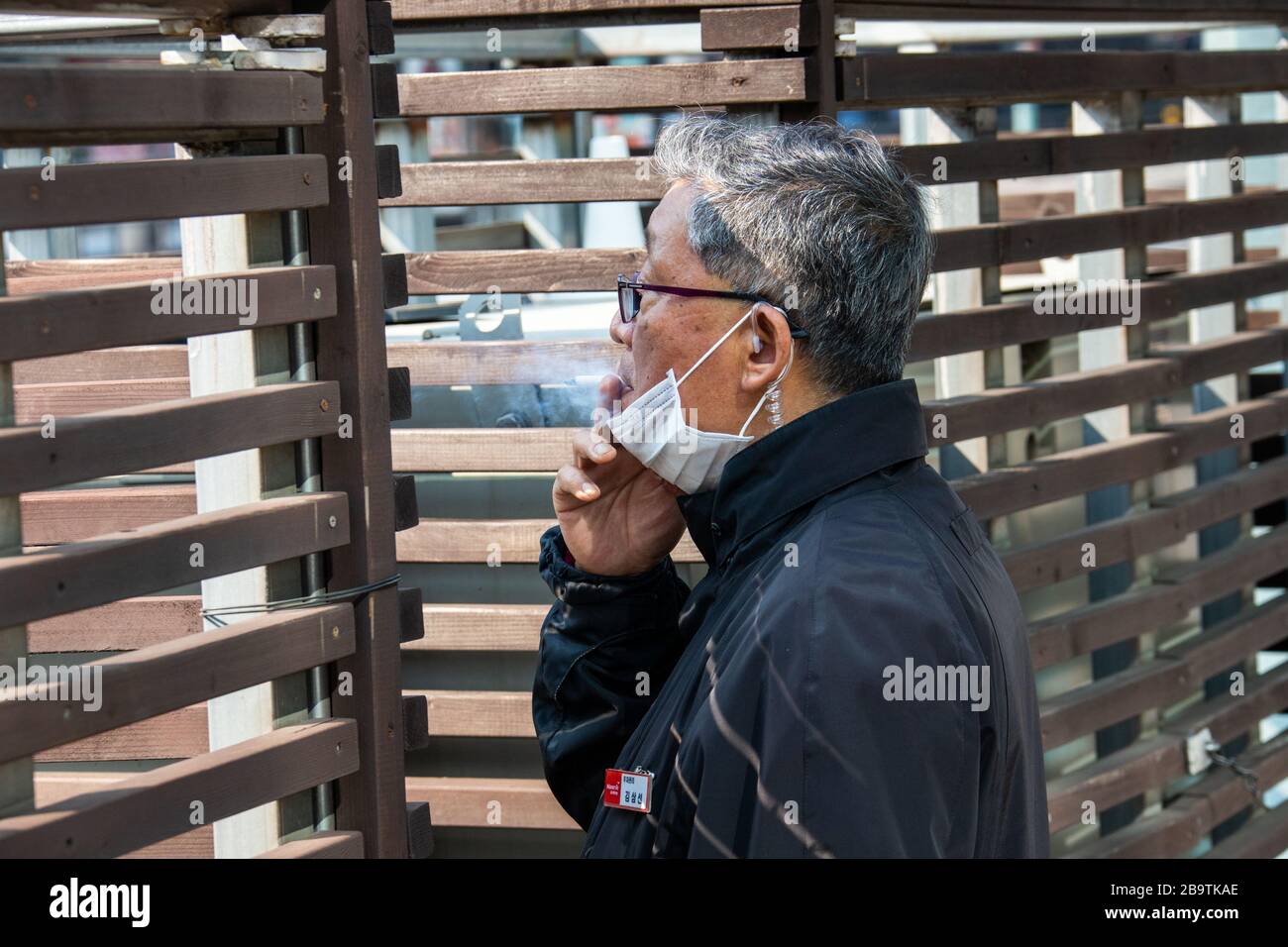 L'homme fume et porte un masque de protection lors de la pandémie de coronavirus à Séoul, en Corée du Sud Banque D'Images