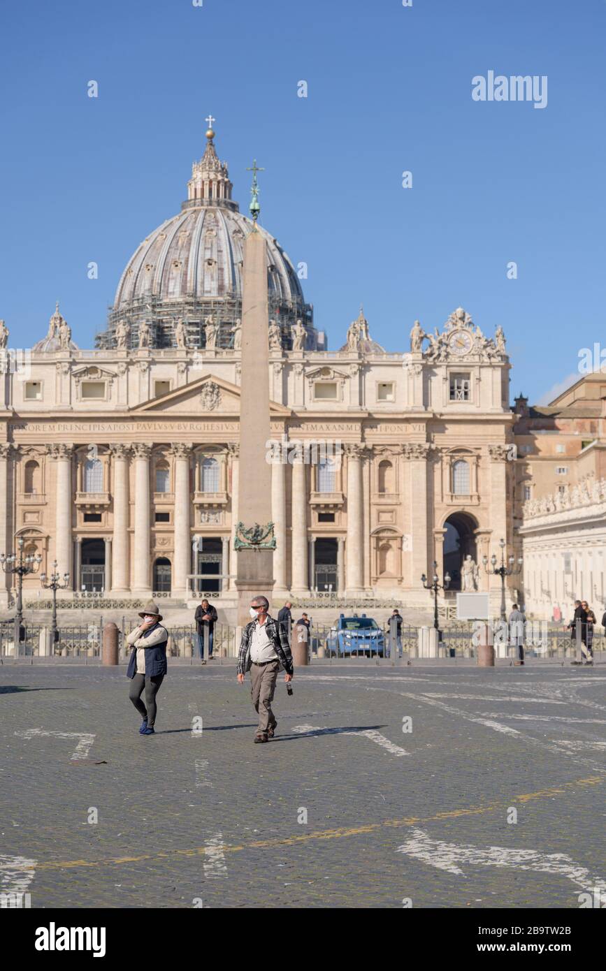 ROME, ITALIE - 12 mars 2020: Les touristes portant des masques de visage marchent autour d'une place Saint-Pierre vide, Vatican, Italie. Suite à la pandémie de coronavirus, Banque D'Images