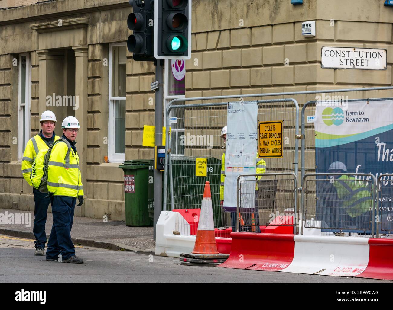 Leith, Édimbourg, Écosse, Royaume-Uni. 25 mars 2020. Tramways pour les travaux de construction de Newhaven : certains ouvriers continuent de travailler sur Constitution Street malgré l'appel du gouvernement écossais à cesser les travaux de construction pendant la pandémie de Coronavirus du Covid-19 Banque D'Images