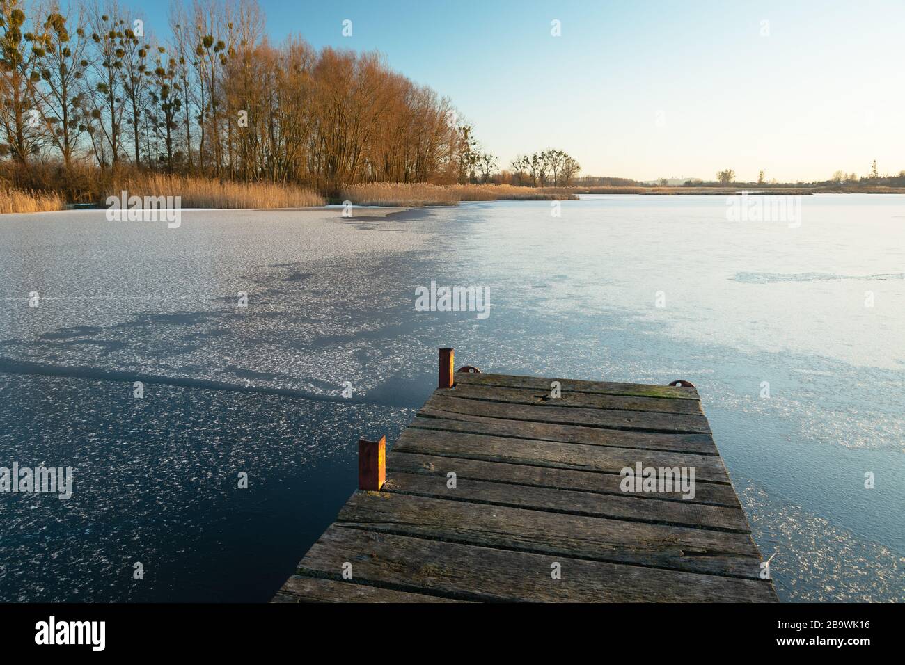 Jetée en bois et lac gelé, vue sur une journée ensoleillée Banque D'Images