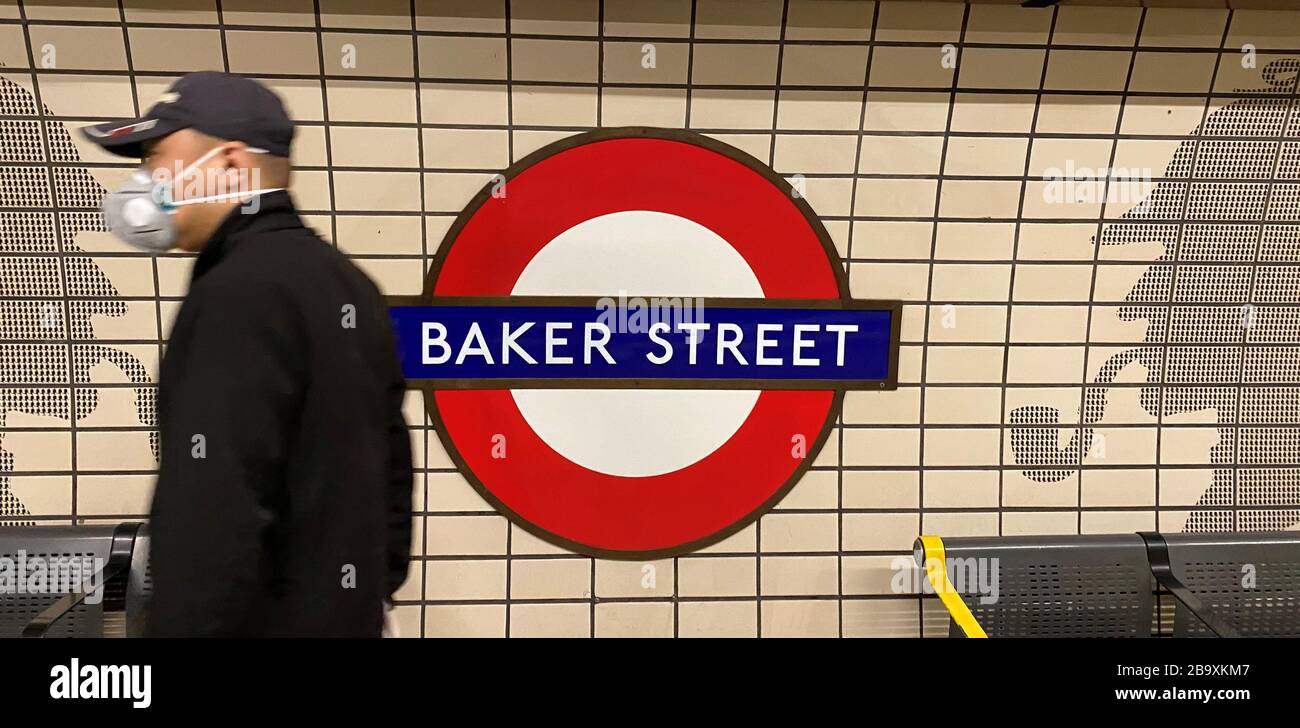 Un homme porte un masque lorsqu'il passe un panneau à la station de métro Baker Street à Londres après que Sean O'Callaghan, Assistant Chief Constable de la British Transport police, a déclaré que seuls ceux qui font des voyages essentiels pour le travail devraient utiliser le réseau de métro et ferroviaire. Banque D'Images