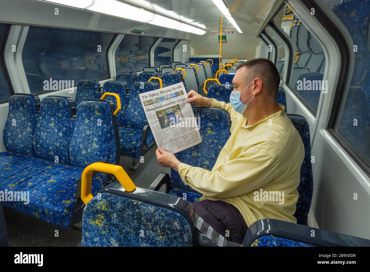 18 mars 2020 : un seul homme sur un train vide lit les nouvelles de Coronavirus du journal The Sydney Morning Herald à Sydney, en Australie, alors que la population abandonne les lieux publics en prévision d'un verrouillage à l'échelle de la ville. À midi, le 23 mars, de nombreuses entreprises et lieux de rassemblement classés par le gouvernement comme non essentiels - tels que des pubs, des restaurants, des plages et même des lieux de culte - ont été fermés et considérés hors limites jusqu'à nouvel ordre. (Modèle libéré) Banque D'Images