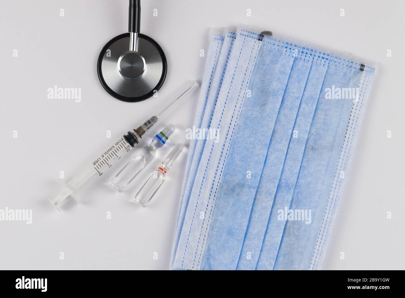 Masques de protection médicale sur fond blanc avec stéthoscope, capsules et seringue. Concept de protection du coronavirus Banque D'Images