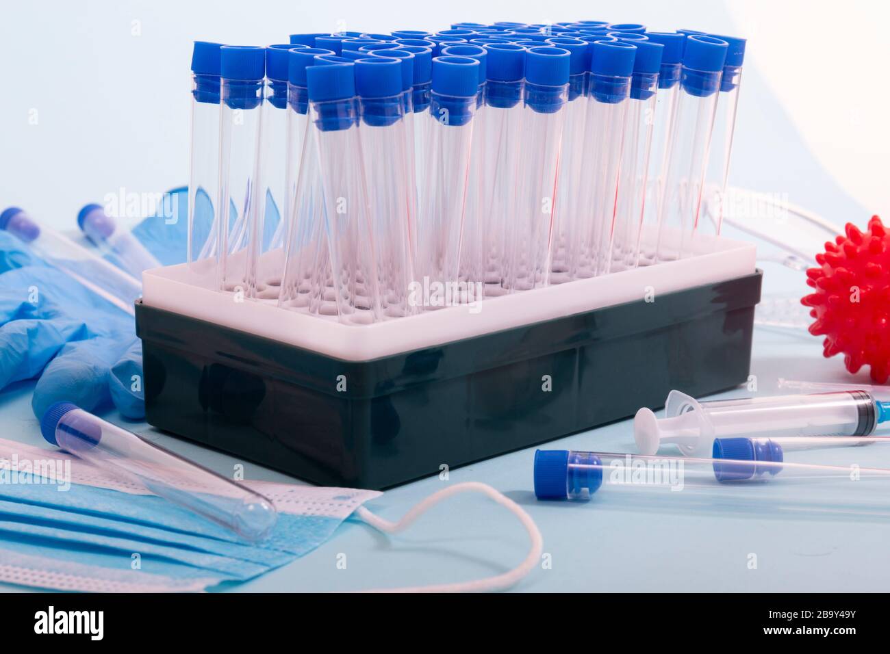 Plusieurs objets de laboratoire, dont un masque de protection, un portoir pour flacons, des tubes de test et d'autres produits. Banque D'Images