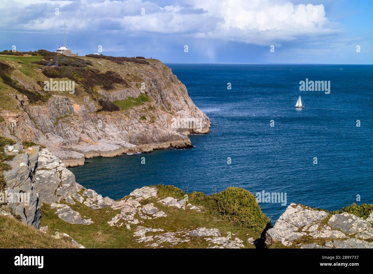 Un bateau à voile qui traverse les falaises de Berry Head, une réserve naturelle près de Brixham, à Devon, Royaume-Uni. Mars 2018. Banque D'Images