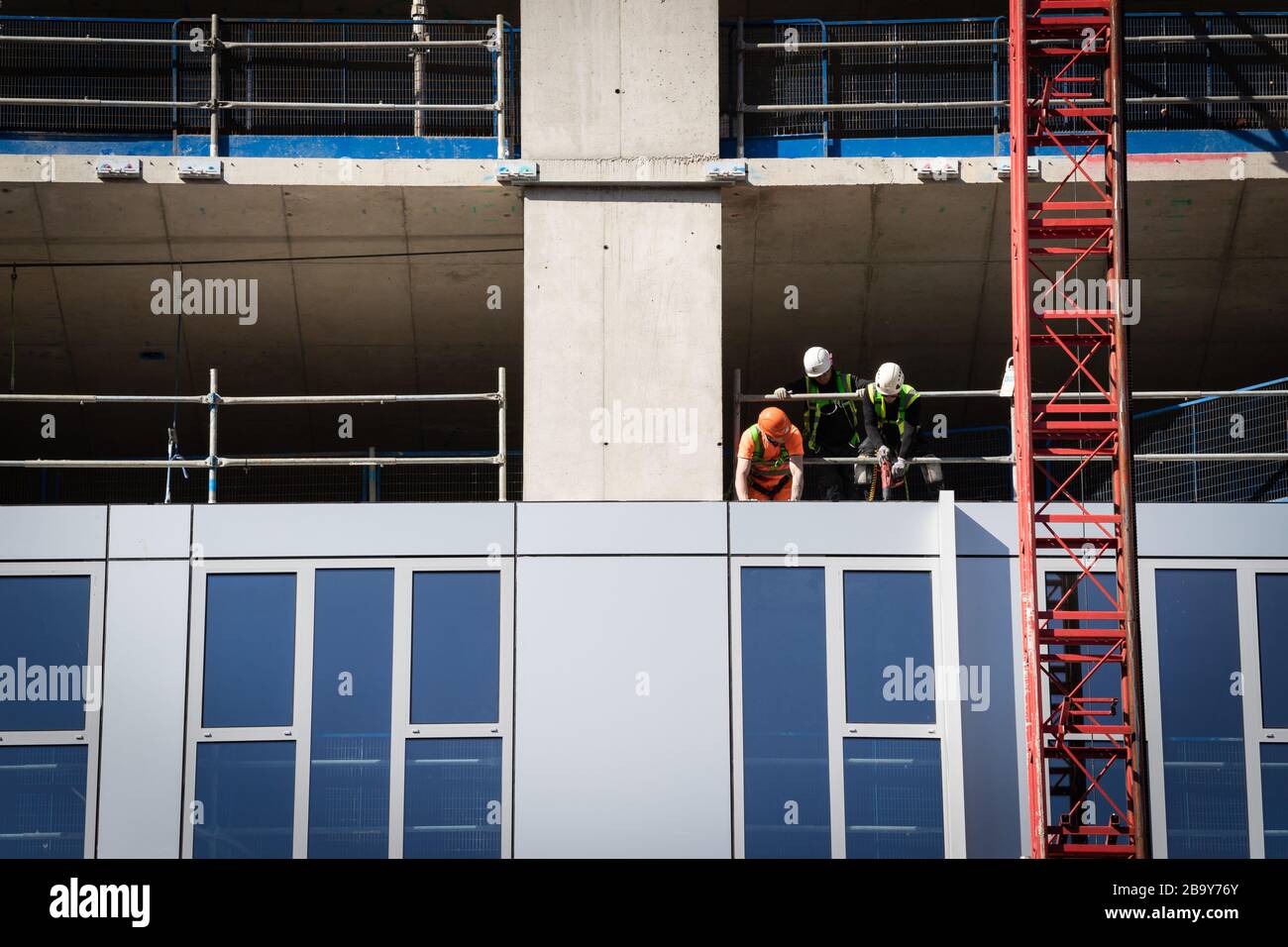 Manchester, Royaume-Uni. 25 mars 2020. Les travailleurs de la construction installent des travaux de revêtement à proximité les uns des autres. Le Cabinet Office a confirmé que la construction en Angleterre peut se poursuivre tant qu'elle peut être effectuée en toute sécurité et en suivant les directives de Santé publique Angleterre. La sécurité des travailleurs de la construction a été largement controversée en raison de la propagation du coronavirus. Crédit : Andy Barton/Alay Live News Banque D'Images