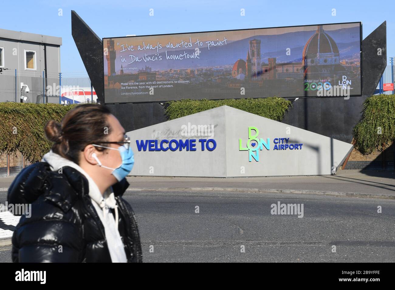 Une femme portant un masque de randonnée à l'aéroport de Londres City qui doit suspendre ses opérations jusqu'à la fin du mois d'avril, en raison d'un effondrement de la demande causé par l'éclosion de coronavirus. Banque D'Images