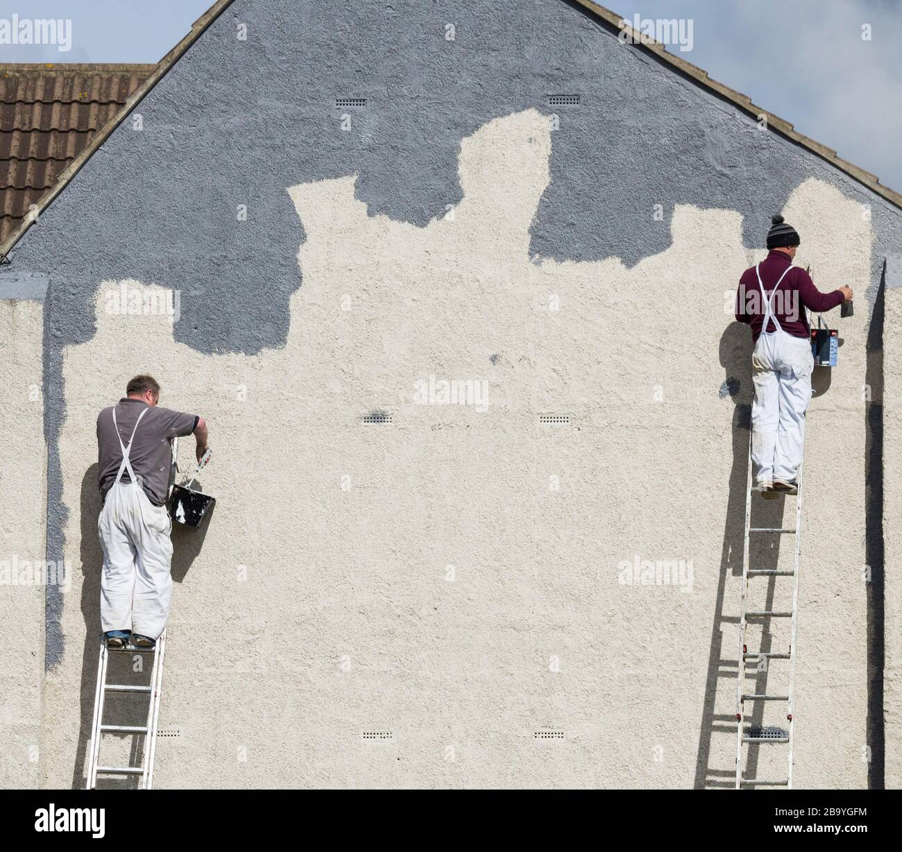 Deux ouvriers peint mur. Concept de distanciation sociale Banque D'Images