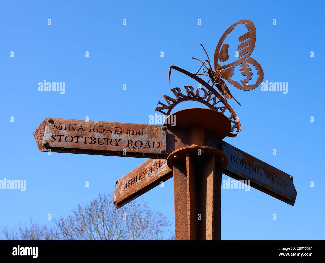 Poteau rouillé de marqueur de fer à Narroways Millenium Green à St Werburghs Bristol UK avec papillon symbolisant le retour de la région à la nature Banque D'Images