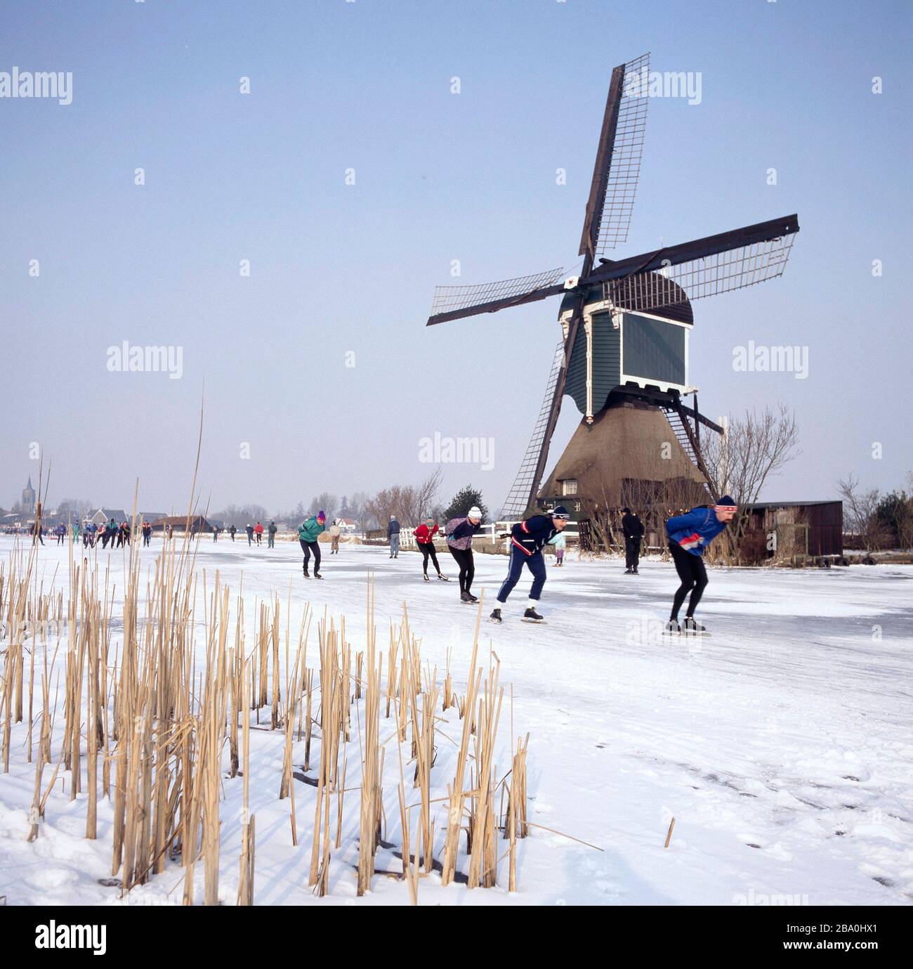 Rotte River, Pays-Bas-février 09,2012 : Moulin à vent et patineurs en hiver avec neige et glace aux Pays-Bas Banque D'Images