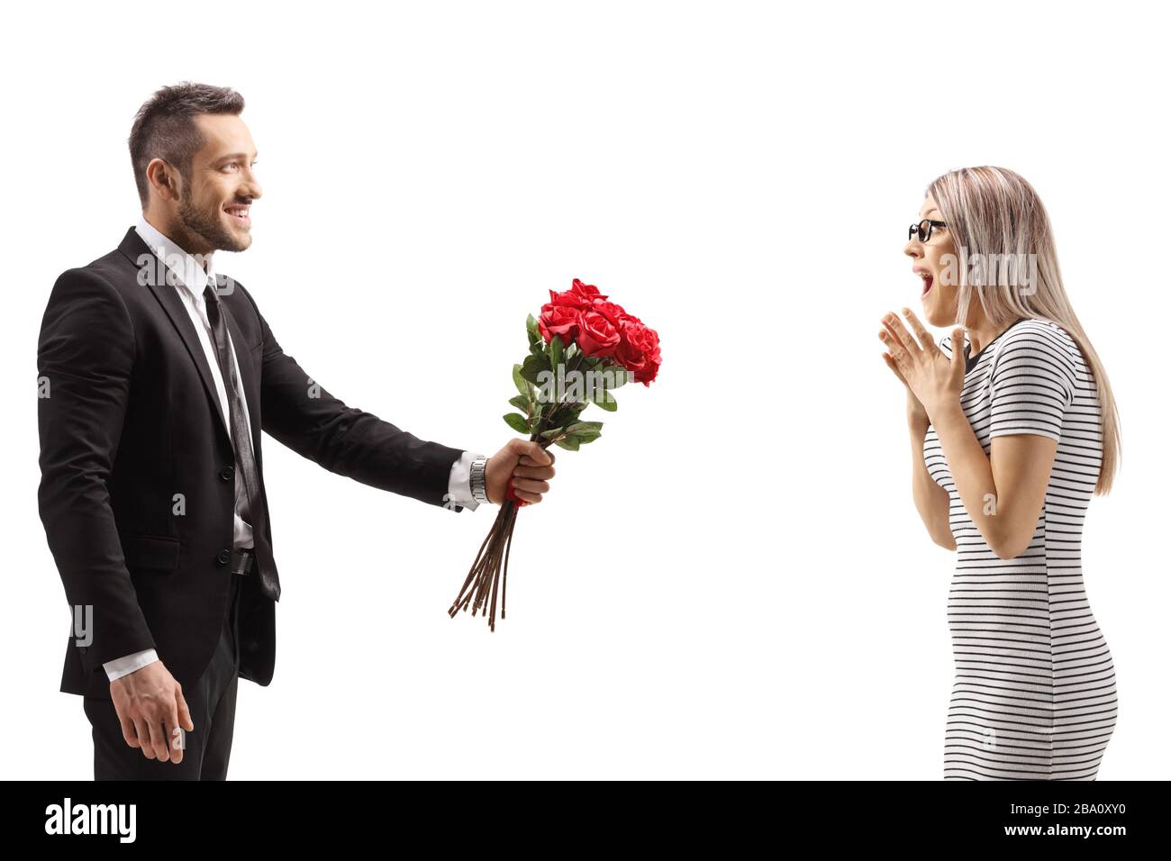 Homme donnant une bande de roses rouges à une femme surprise isolée sur fond blanc Banque D'Images