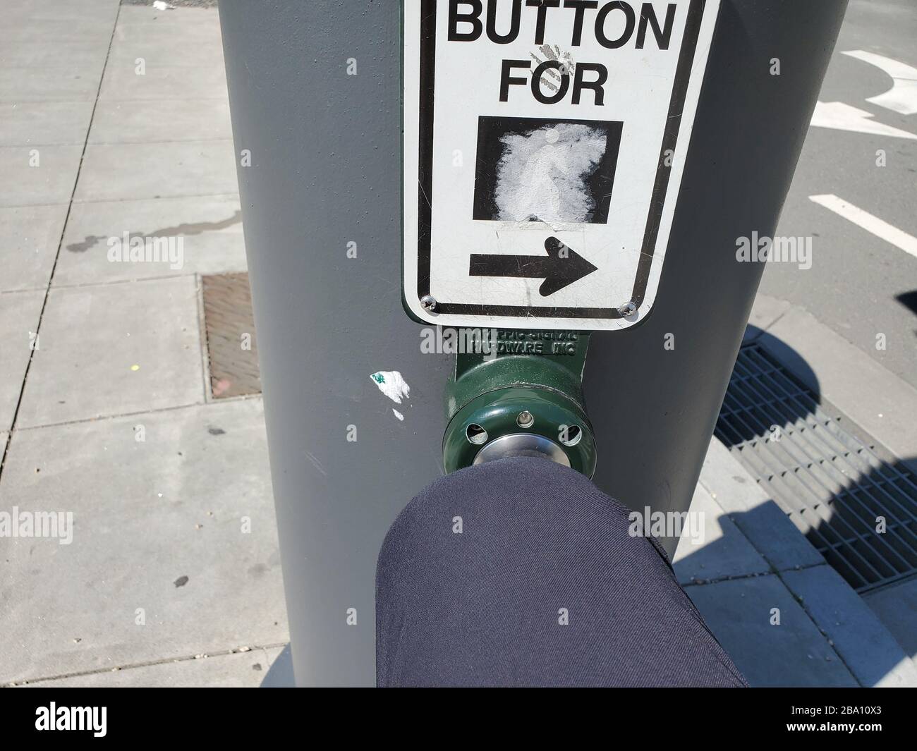 Gros plan sur la personne qui utilise son genou pour appuyer sur un bouton de passage, afin d'éviter tout contact avec la main lors d'une éclosion du coronavirus COVID-19 à San Francisco, Californie, le 19 mars 2020. () Banque D'Images