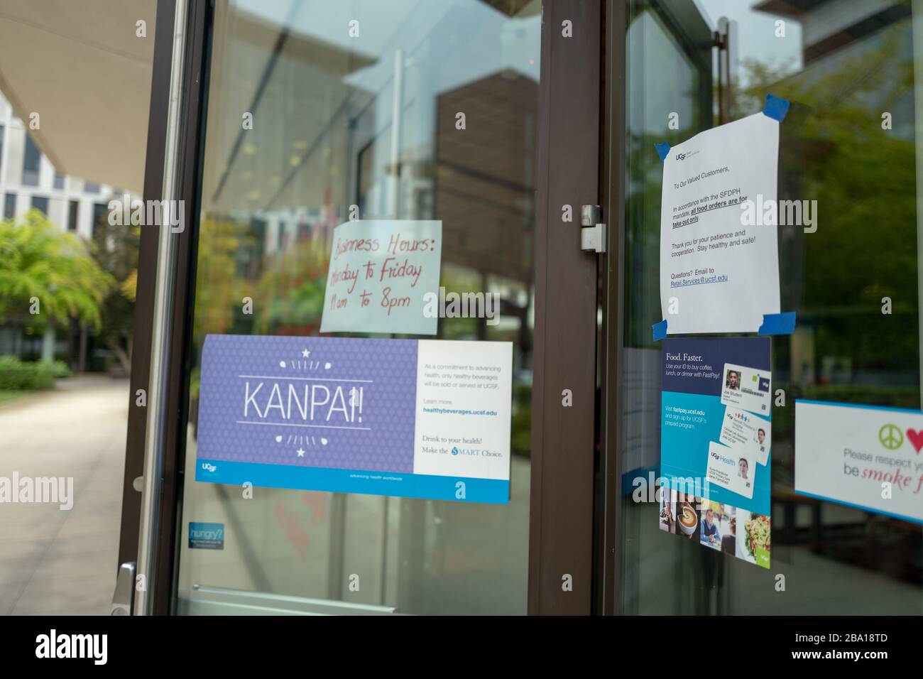 Des panneaux à la porte annoncent des changements aux procédures dans un restaurant qui reste ouvert à Mission Bay lors d'une éclosion du coronavirus COVID-19 à San Francisco, Californie, le 23 mars 2020. () Banque D'Images