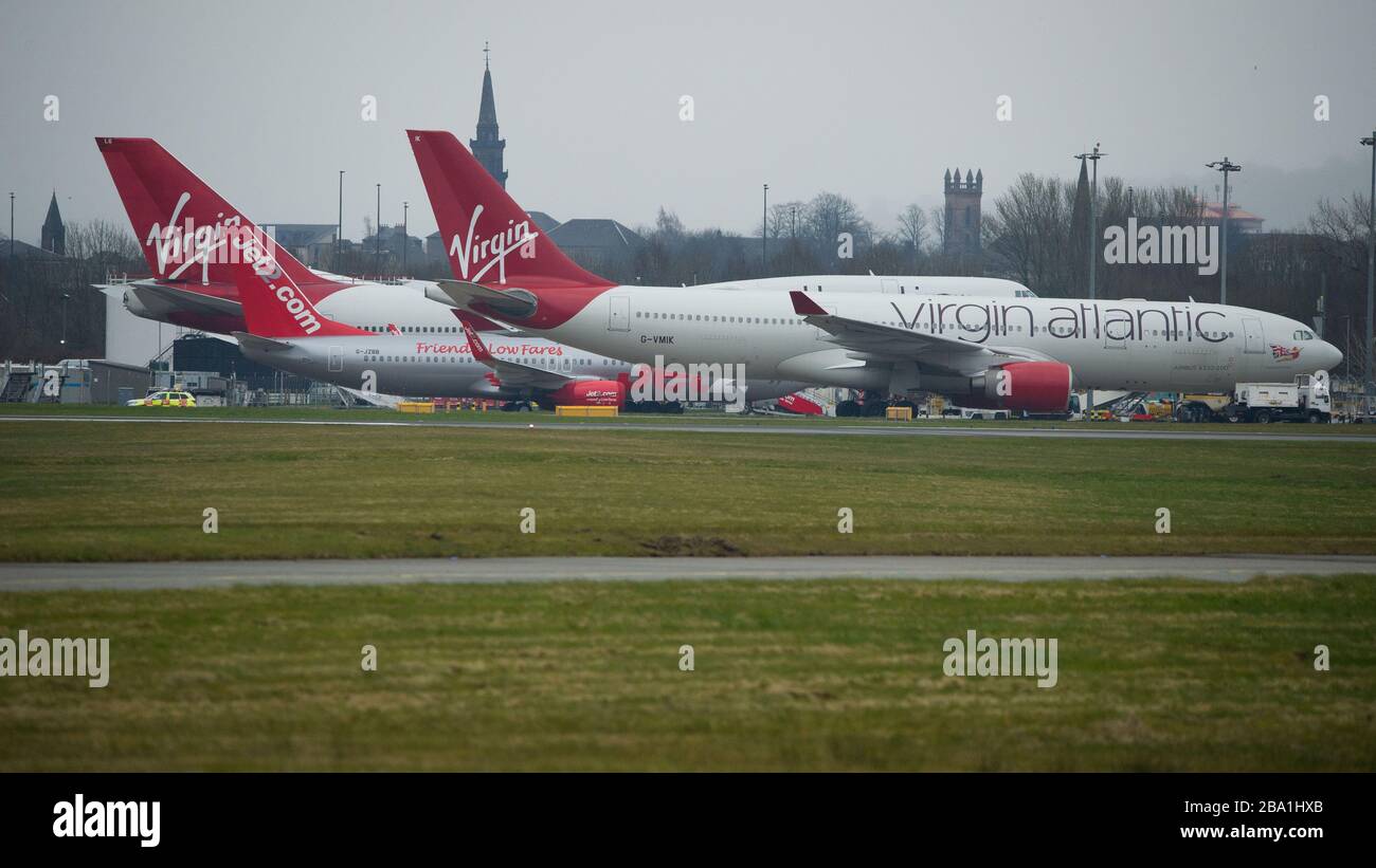 Glasgow, Royaume-Uni. 25 mars 2020. Photo : les avions Virgin Atlantic (Boeing 747-400 - nommé Ruby Tuesday, enregistré G-VXLG) et un Airbus A330-200 - nommé Honkytonk Woman, enregistré G-Vmik) sont mis à la terre sur le tarmac par le cintre Logan Air. Crédit : Colin Fisher/Alay Live News Banque D'Images