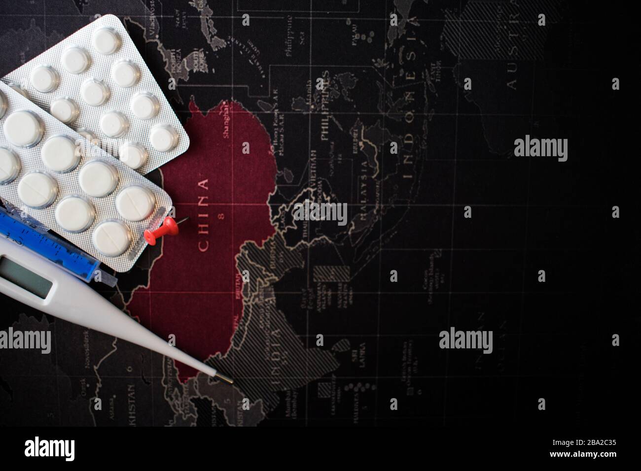 Coronavirus COVID-19. Concept de guérison représentant le virus chinois de Wuhan avec des pilules et une seringue. Carte du monde en arrière-plan. Grippe dangereuse Ca Banque D'Images
