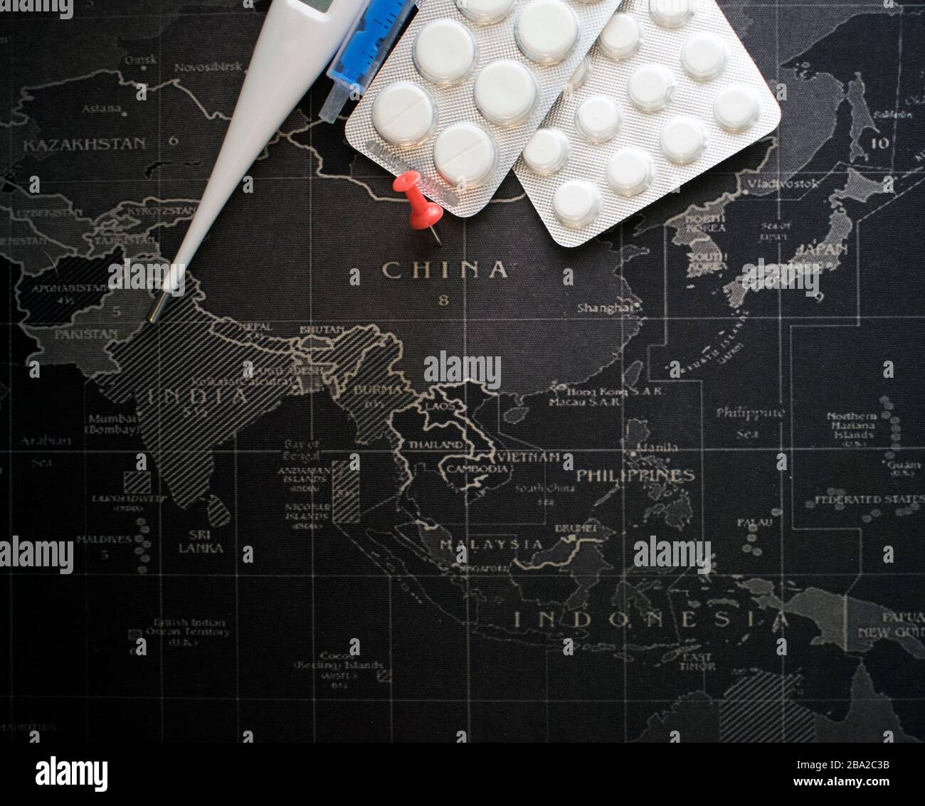 Coronavirus COVID-19. Concept de guérison représentant le virus chinois de Wuhan avec des pilules et une seringue. Carte du monde en arrière-plan. Grippe dangereuse Ca Banque D'Images