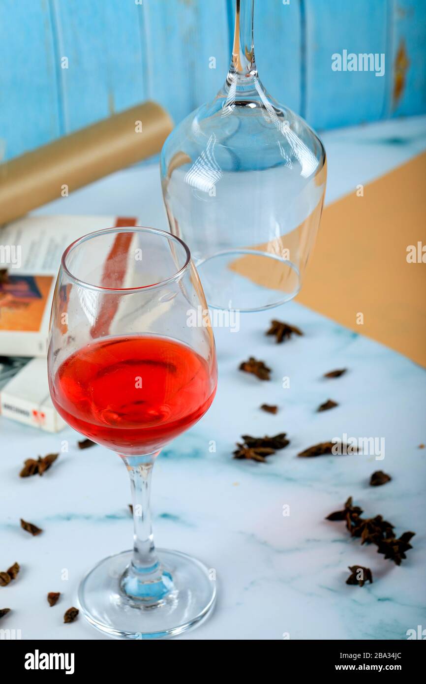 Rose rouge dans un verre et un verre vide sur la table Banque D'Images