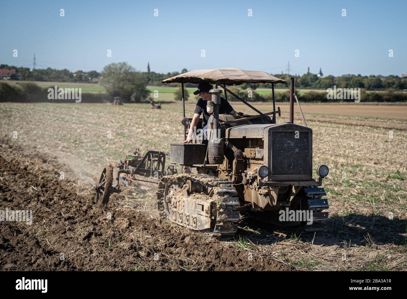 Ancien et ancien famo catapillar travaillant avec une charrue dans les champs, montrant comment l'agriculture a été faite il y a de nombreuses années. Banque D'Images