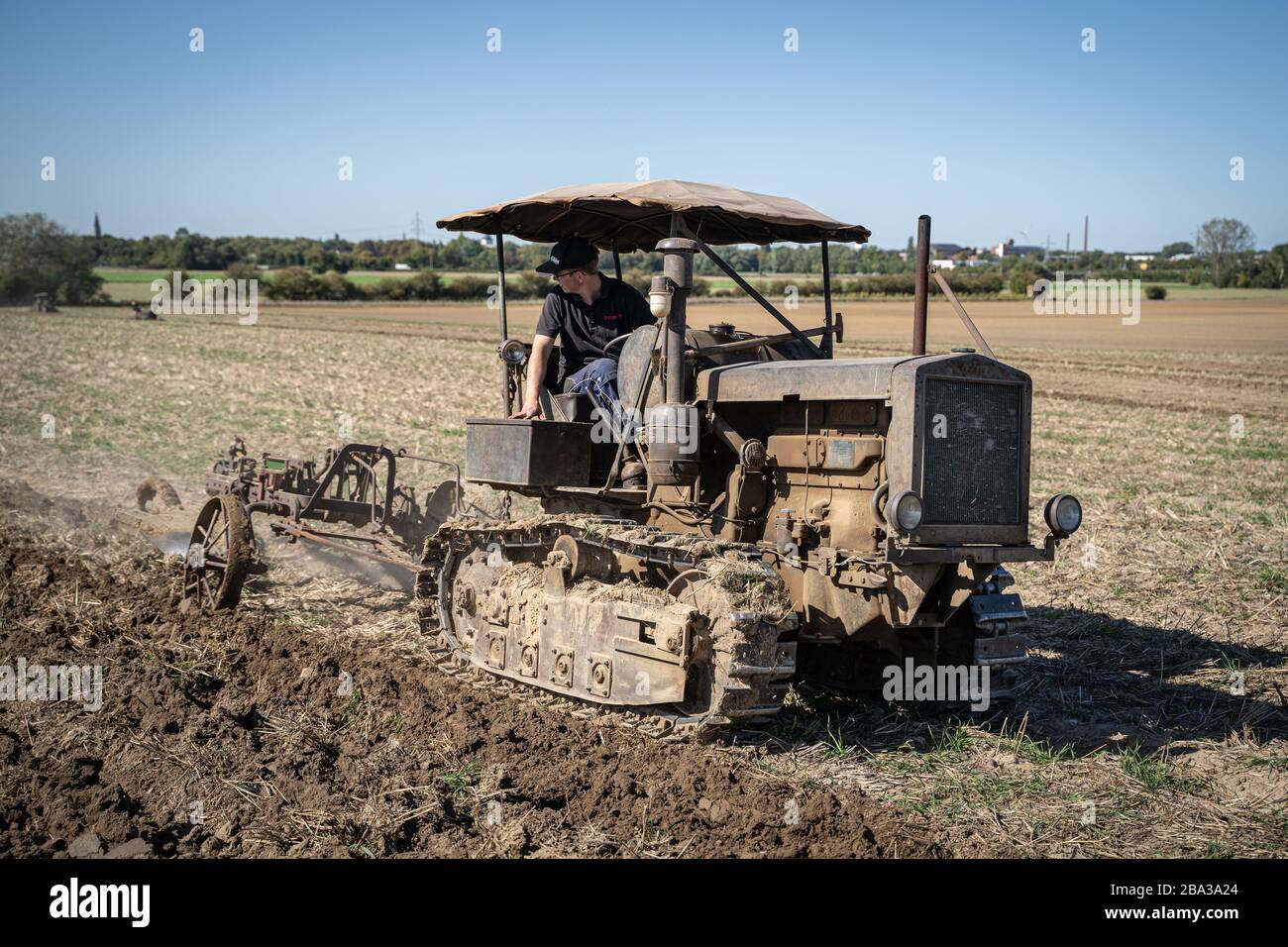 Ancien et ancien famo catapillar travaillant avec une charrue dans les champs, montrant comment l'agriculture a été faite il y a de nombreuses années. Banque D'Images