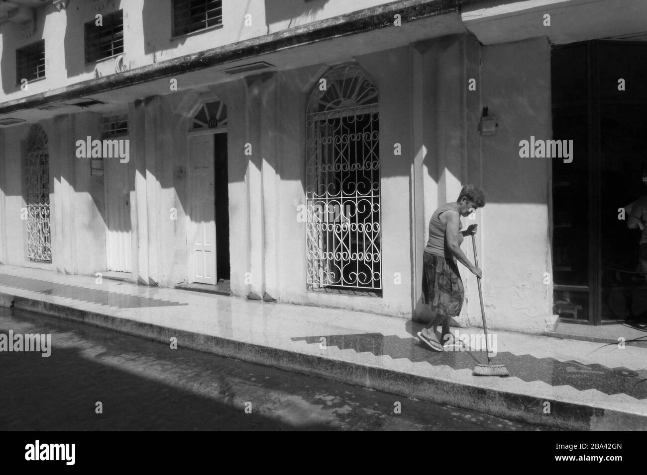 nettoyage des lady et rues balayées avec brosse à la Havane Cuba laver le sol dans la rue vieux style grill et gravant chaussée humide style extérieur Banque D'Images