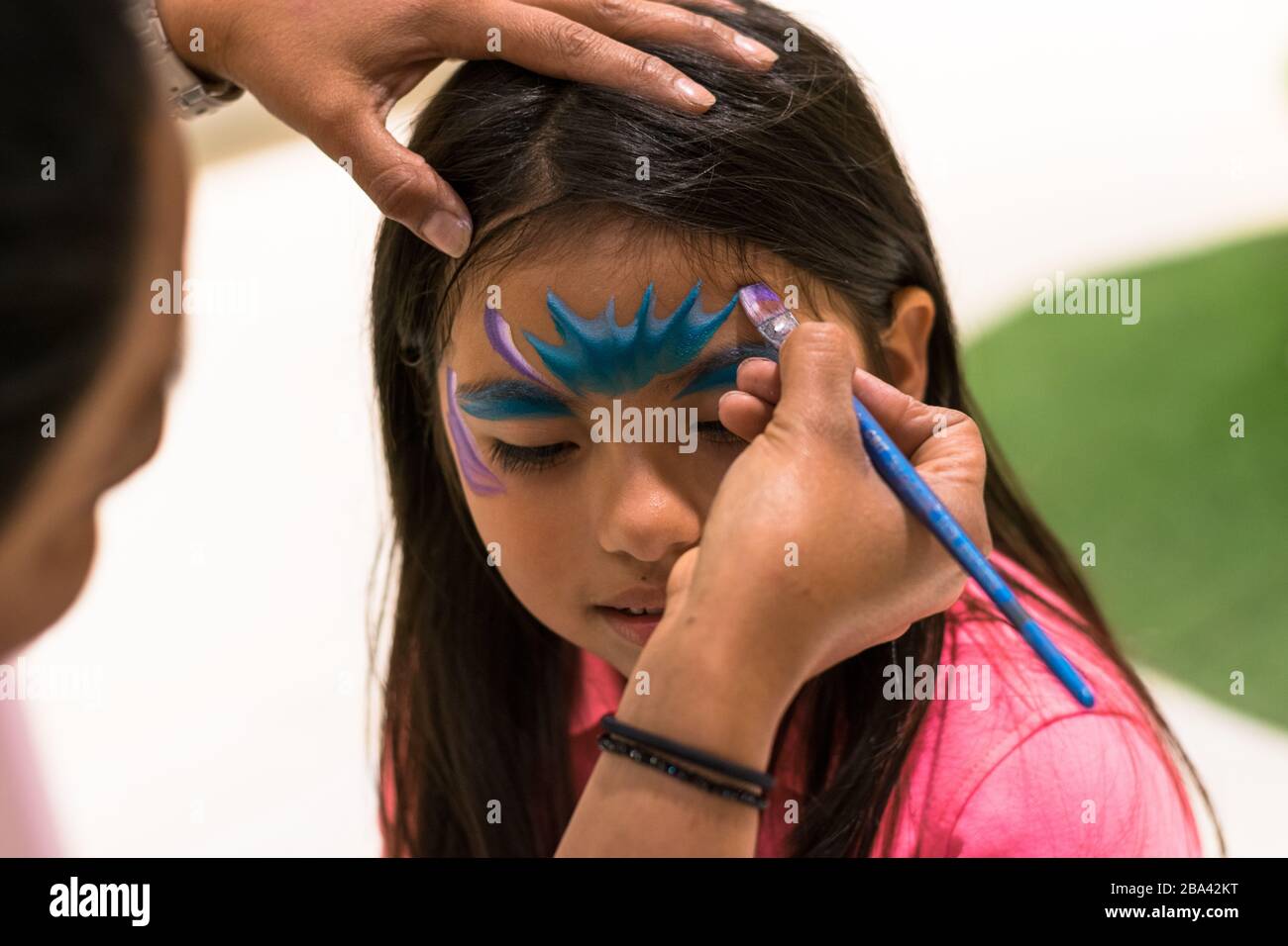 Girl painting son visage comme une princesse par face painting artist Banque D'Images