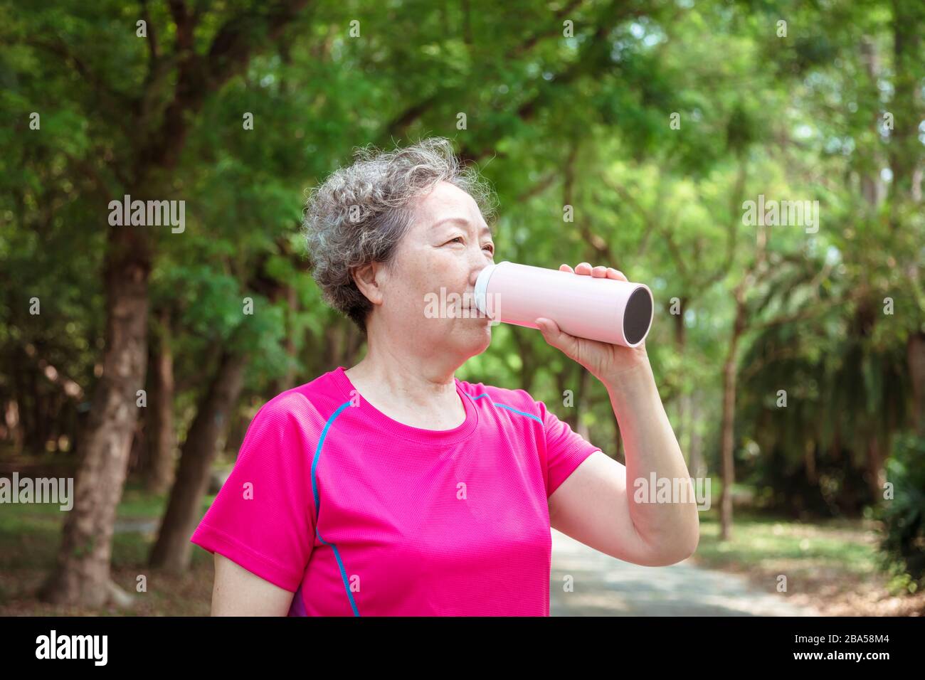 asian Senior femme boire de l'eau après l'exercice Banque D'Images