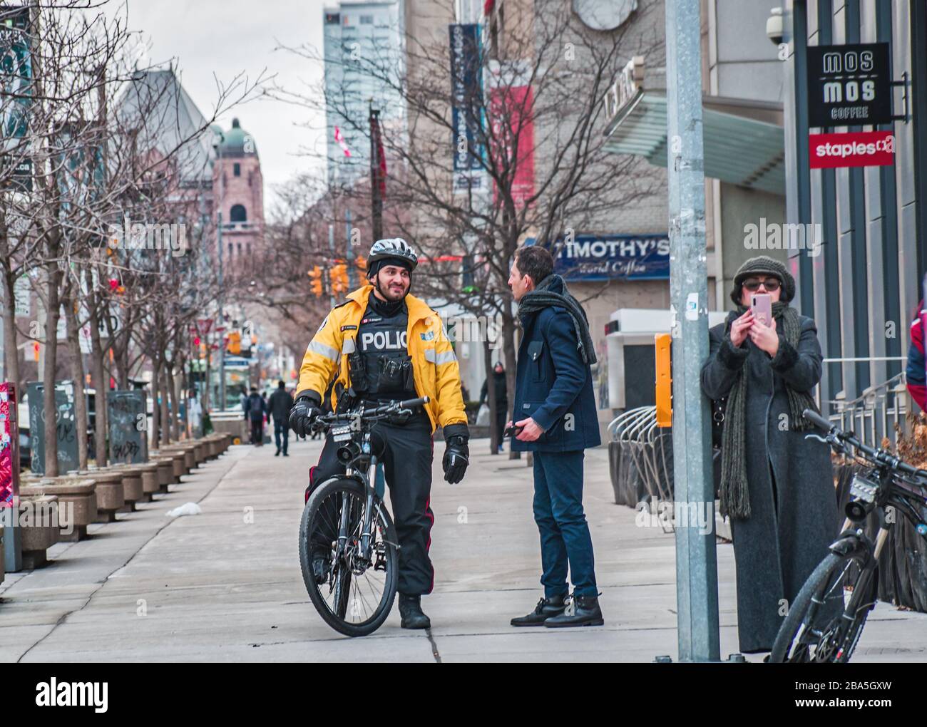 TORONTO, CANADA - 01 04 2020: Agent de patrouille à vélo de la police de Toronto qui parle avec un homme sur l'avenue University du centre-ville de Toronto Banque D'Images