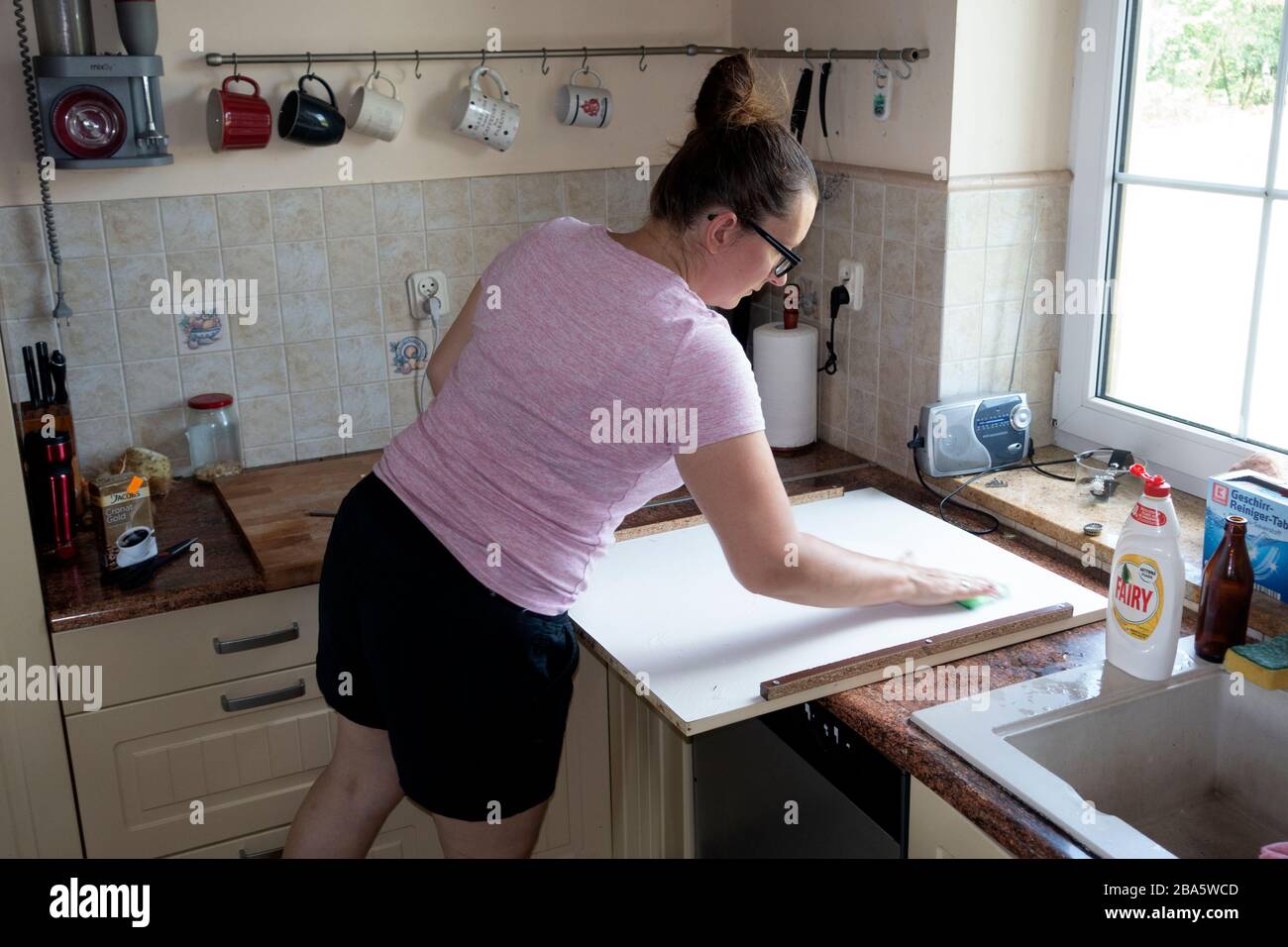 Femme lissant le dessus du nouveau lave-vaisselle dans la cuisine. Zawady Gmina Rzeczyca Pologne Banque D'Images