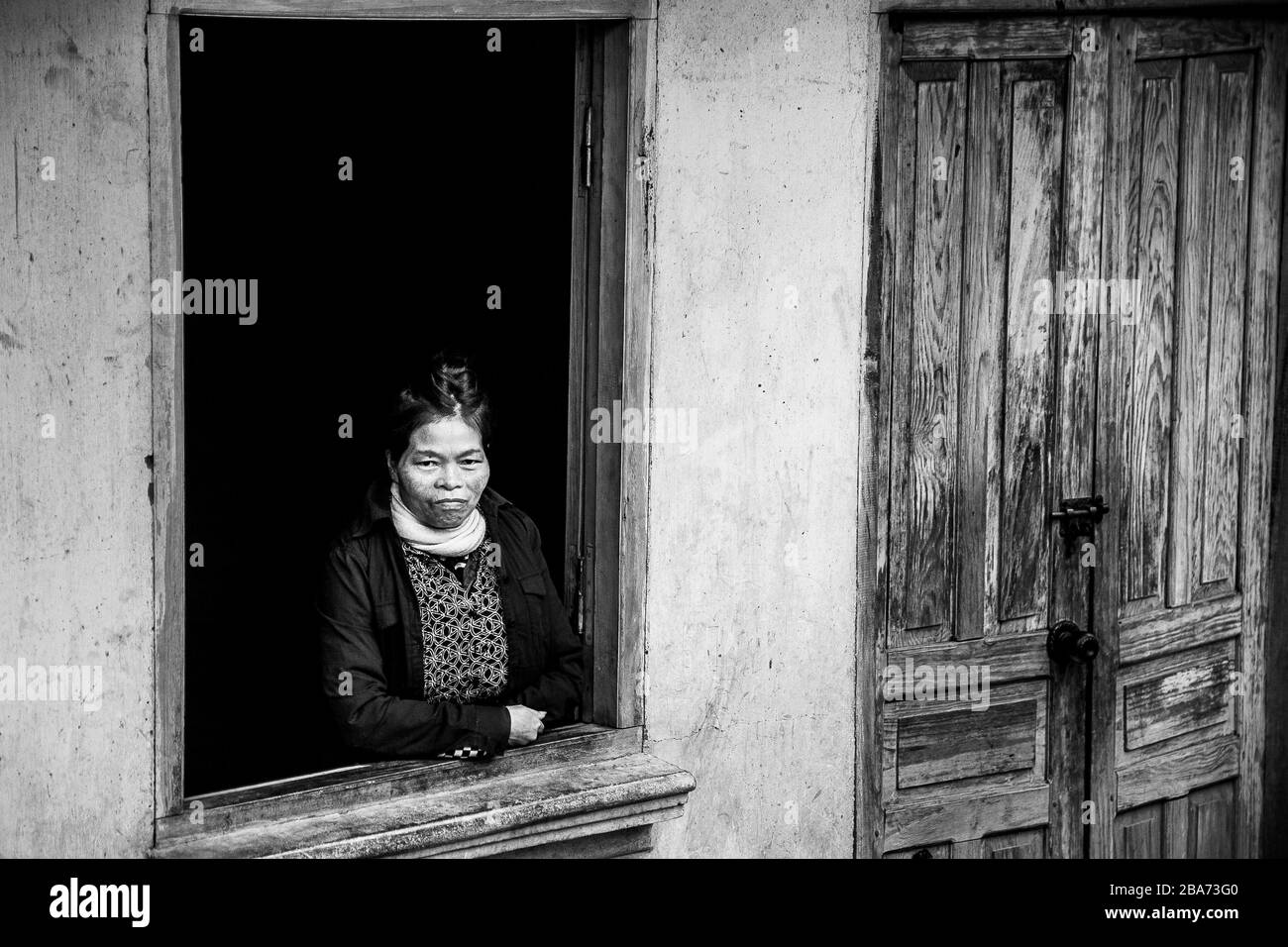 Femme du village à la fenêtre Banque D'Images