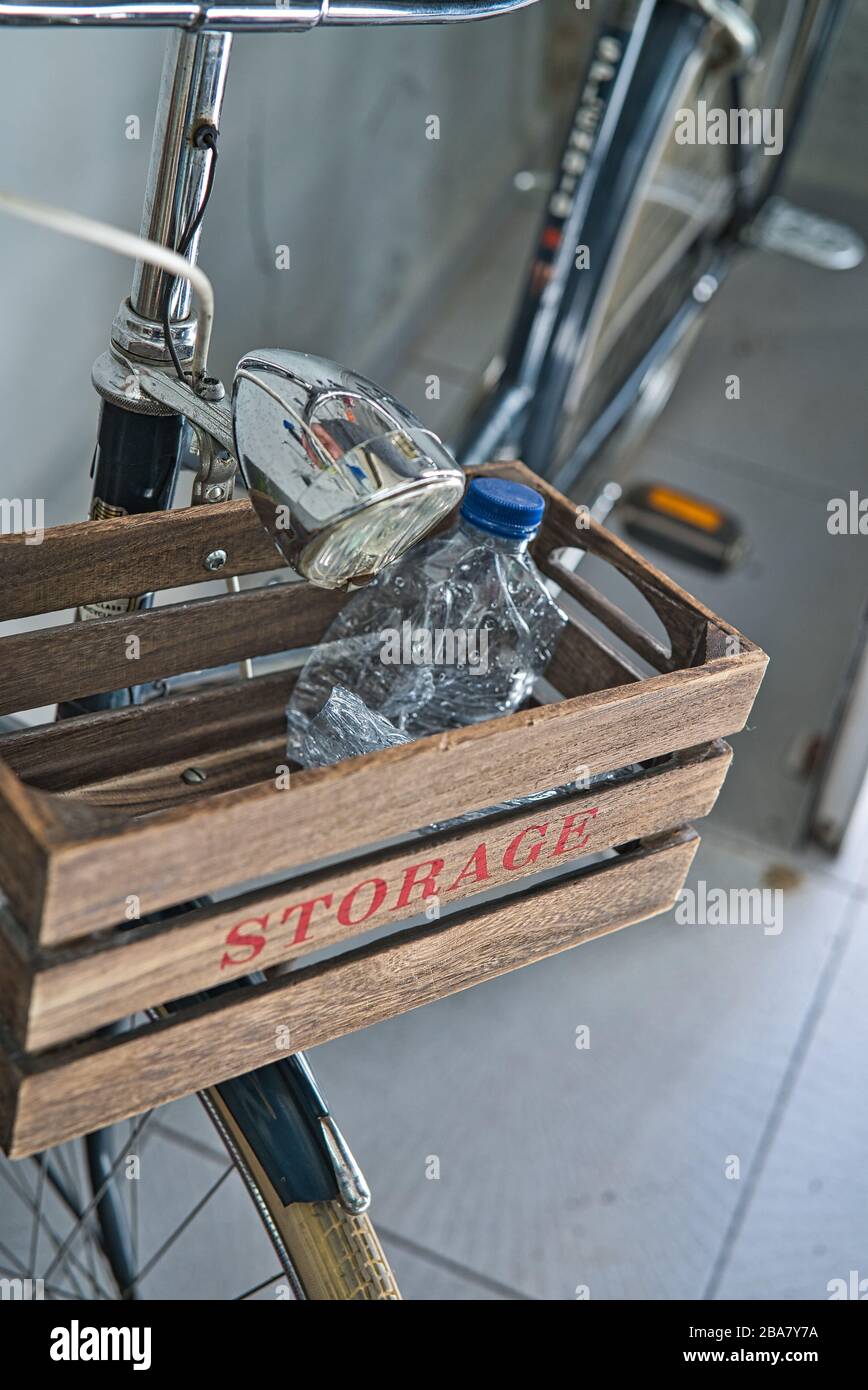 Gros plan d'une bouteille en plastique pour recyclage dans un panier en bois d'une moto ancienne avec le texte « stockage » peint en rouge Banque D'Images