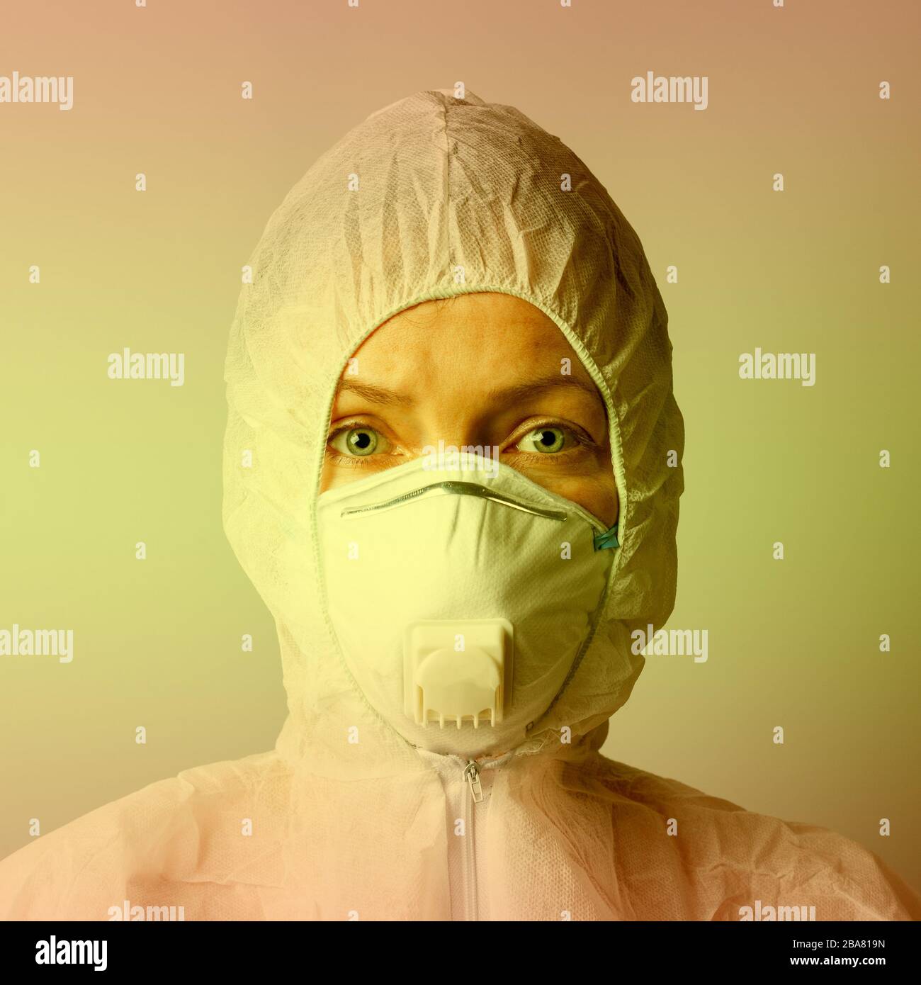 Femme en masque et costume de protection, concept de protection, gros plan, tonification jaune. Banque D'Images
