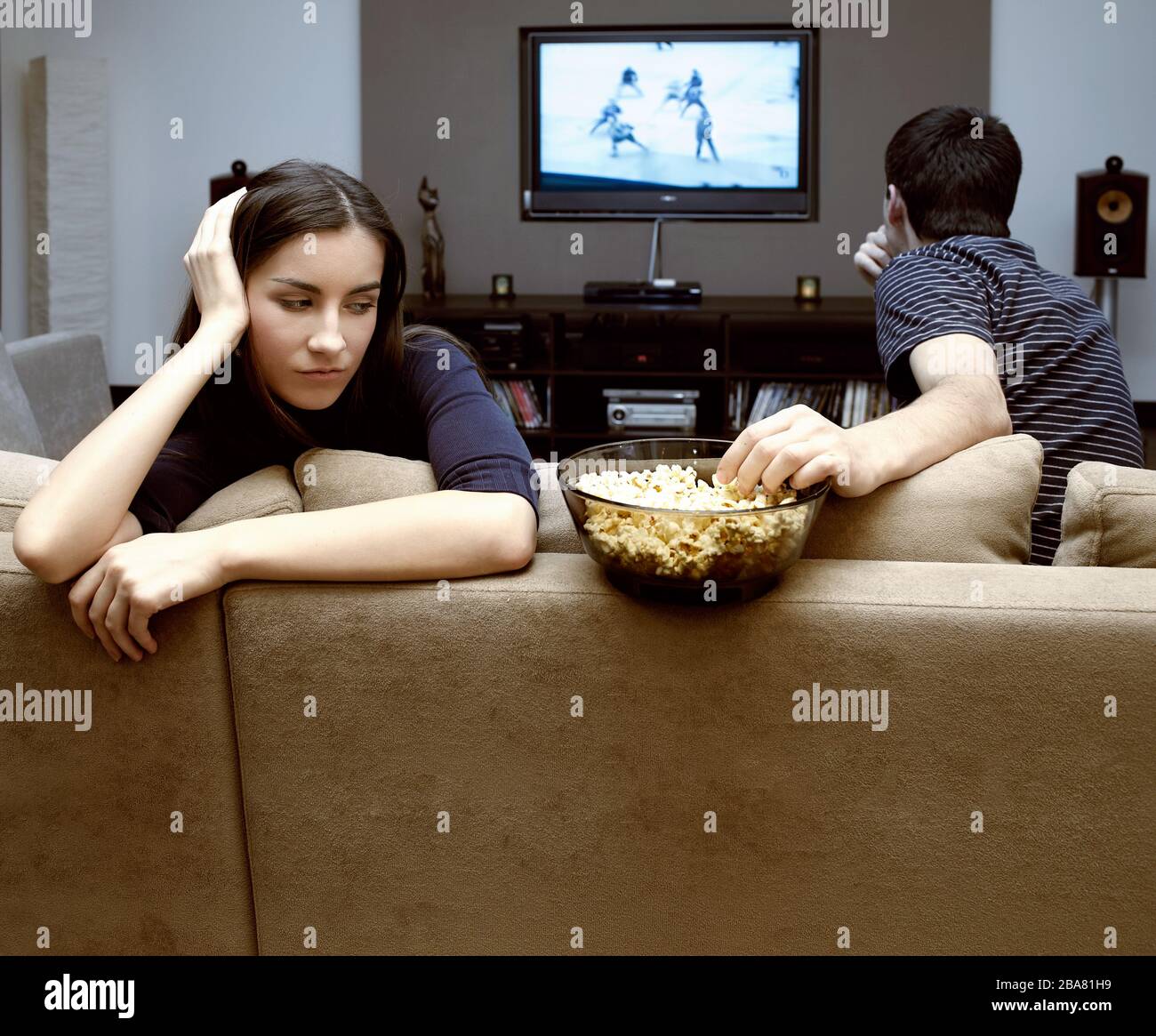 Auto-isolement dans une maison de quarantaine d'un jeune couple pendant une pandémie de coronavirus. Un homme et une fille regardent la télévision. Banque D'Images