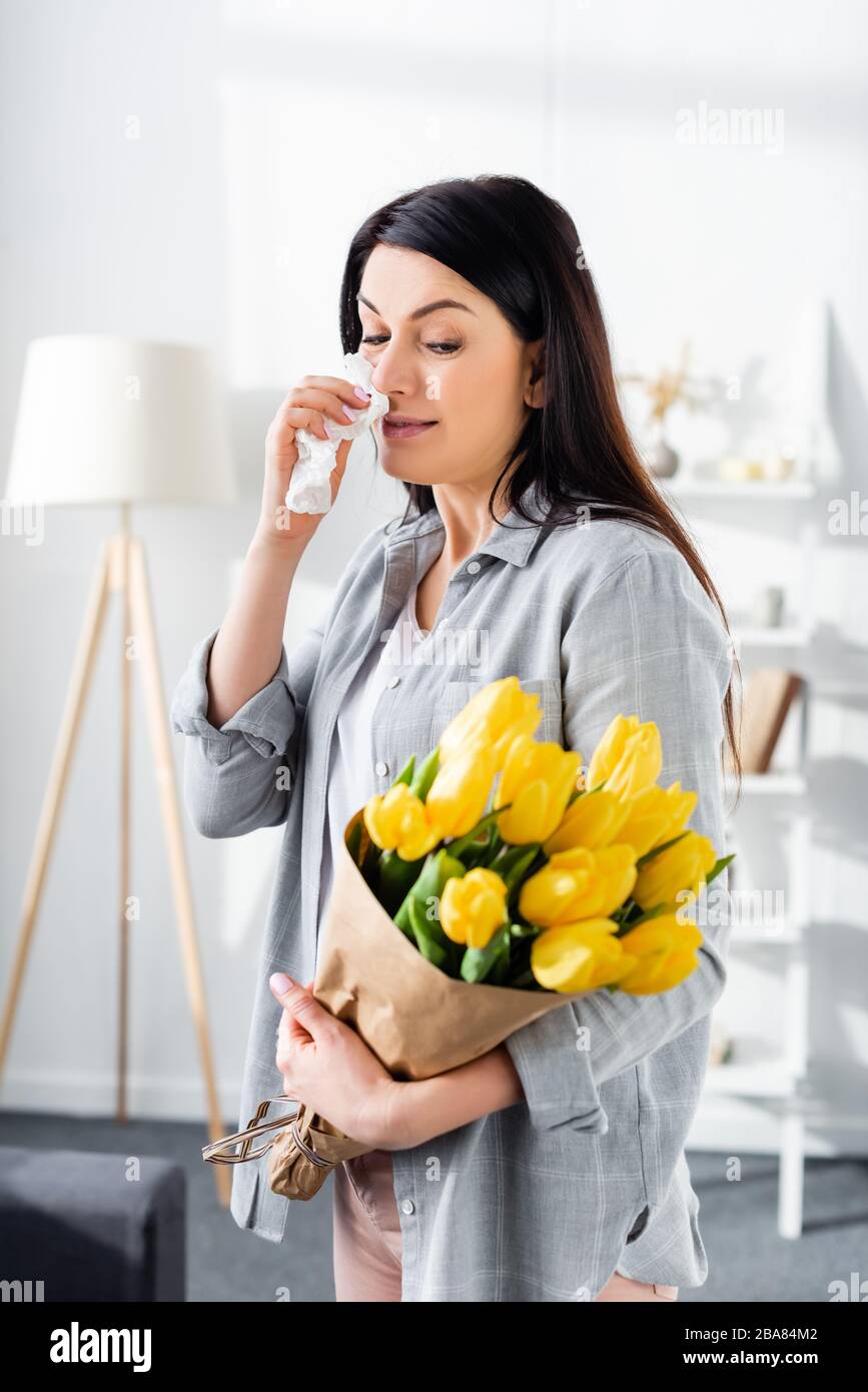 femme allergique au pollen et nez courant tenant tulipes Banque D'Images